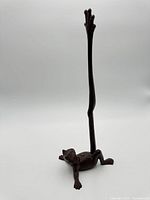 Full view of cast iron frog paper towel holder showing entire height and design