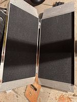 Ramp unfolded showing black grit tread and hinge