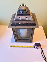 front view showing lantern, candle and measuring tape