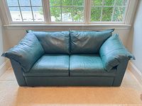 Front view of green bonded leather loveseat