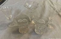 Group shot of two stemmed glasses, two rocks glasses and ruffled rim vase