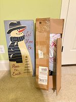 Painted snowman sign, shipping box beside
