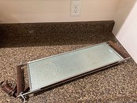Top view of Salton Hotray rectangular warming tray with wood handles and power cord on countertop