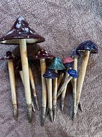 Front view showing variety of ceramic mushroom caps and wooden stakes