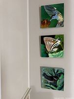 three ceramic plaques mounted vertically on wall
