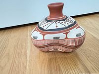 front view of squat terracotta vase showing painted geometric patterns and neck