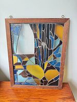 Full front view of stained glass panel showing design, frame and hanging hooks