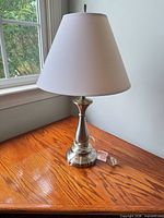 Full view of lamp with shade on wooden surface