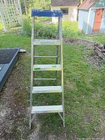 Full front view of 5 ft aluminum step ladder showing treads and wear