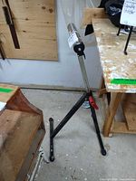 Full view of adjustable tripod stand showing legs and telescopic post