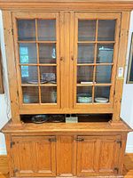Full view of pine china cabinet showing upper glass doors, open ledge, and lower cabinet