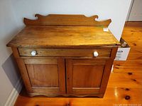 Front view of solid pine cabinet showing drawer, doors, ceramic knobs, overall form