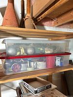 Plastic tote on shelf showing contents and red lid