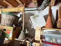 overview of lot on shelves showing chandelier frame, metal plunger, basket, boxes