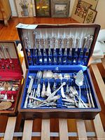 open Birks flatware chest with assorted pieces displayed