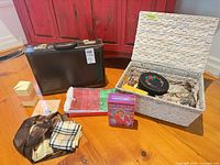 Group shot of all items: briefcase, basket with contents, scarves, chevron box, DVD