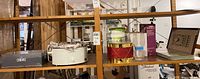 Shelf view showing Crock-Pot, decorative drum box, whey tub, CANVAS box, champagne flute box and framed sampler