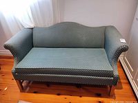 Full view of green patterned loveseat sofa showing overall design