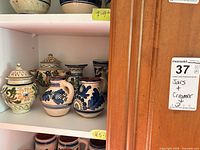 Shelf with assorted Talavera earthenware including creamers, lidded jars and vases