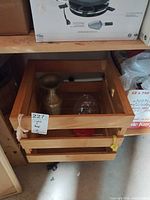 Wooden crate containing brass vase and glass feeder