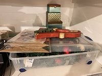 Lot overview showing tote with wreath, stacked gift boxes, packaged gift bags, wooden Santa