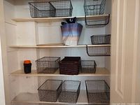 Closet shelves holding various wire baskets, wicker basket, tote bag, flashlight