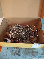 Box containing mixed costume jewelry pieces