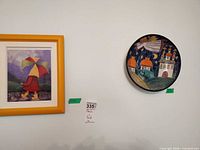 Framed print and ceramic plate on wall side by side