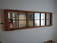 Front view of rectangular rustic wood windowpane mirror mounted on wall