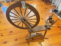 Full left side view of spinning wheel showing drive wheel, bench, treadle