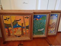 Front view of three framed paintings showing subjects and frame style