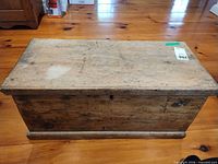 Front view of solid wood trunk showing distressed surface and base molding
