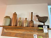 Shelf view showing five stoneware pieces and wooden chicken figure