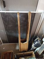 Full view of wood tabletop ironing board standing upright