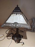 Full view of lamp showing stained glass shade, metal base, power cord
