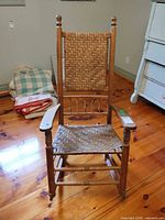 Front view of wooden rocking chair with woven seat and back