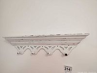 white distressed wood wall shelf with hooks mounted on wall