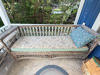 Full view wicker rattan sofa with cushion and pillow on porch