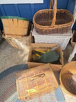 Assorted baskets stacked with cardboard box containing tools visible