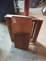 Group of wood boards and frames leaning against post
