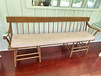 Front view of entire wood Windsor bench with cushion
