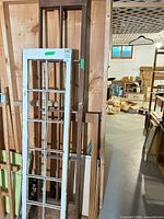 Group of wooden window frames leaning against wall