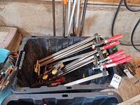 Bin containing six red-handled F-clamps and corner clamp