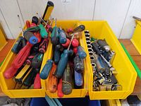 overview of yellow bin with screwdrivers and sockets