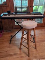 Keyboard on X-stand with stool in front