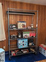 Full view of chrome wire shelving unit with five shelves installed and items placed for scale