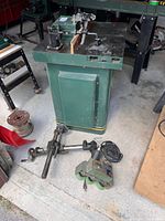 Front view of Craftex shaper, cabinet stand and loose spindle parts on floor