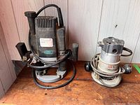 Freud plunge router and Black & Decker fixed-base router side by side on workbench
