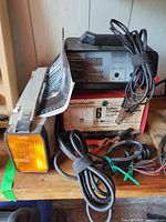 Battery charger, work light, cables visible