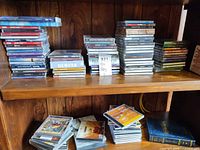 Two shelves of stacked CDs and DVDs